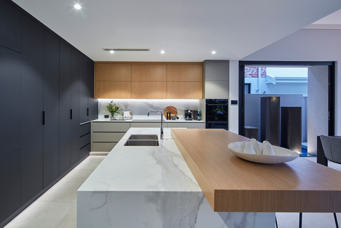 Custom luxury modern kitchen island with wooden details and glossy dark cabinets by Perth boutique home builder Trendsetter Homes.